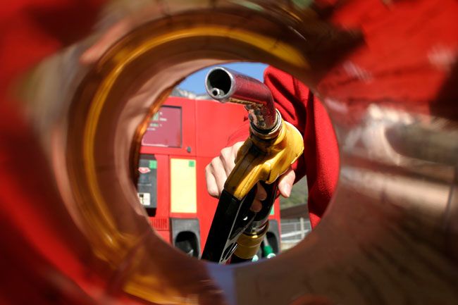 A fleet driver about to fuel his truck at a gas station from the perspective of the fuel tank.