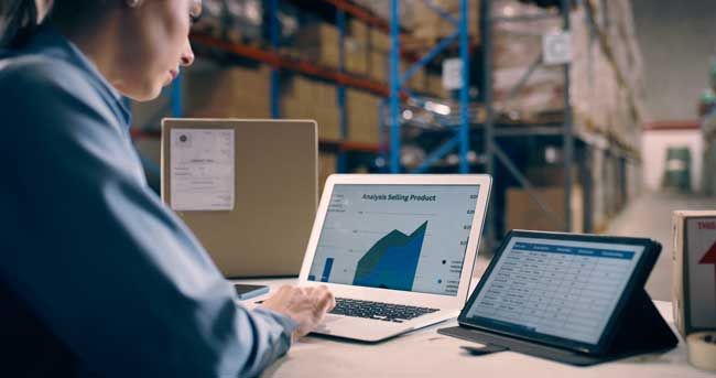 A fleet manager reviews real-time data on a computer from fleet card users.