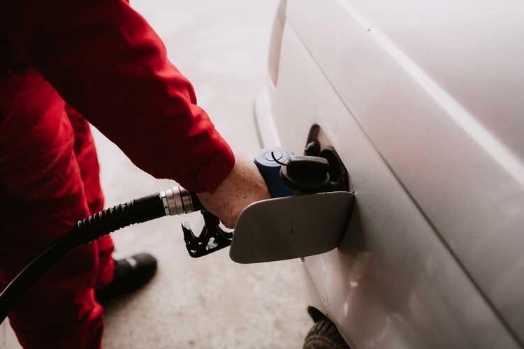 A fleet driver fueling his van at a gas station.