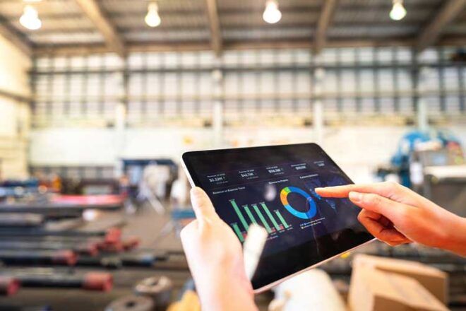 A business owner reviewing fleet card usage data from a tablet.