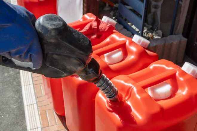 A truck driver fuels up portable fuel tanks.