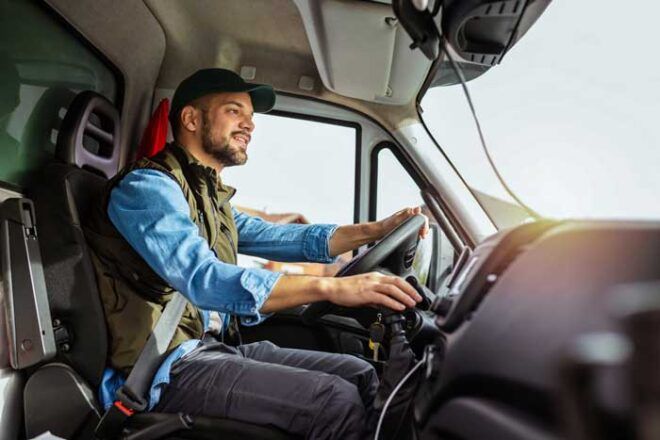 A truck driver in the cab of his fleet.